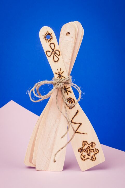 Puidust pannilabidad seismas, kus esimesele labidale on põletatud erinevad mustrid.